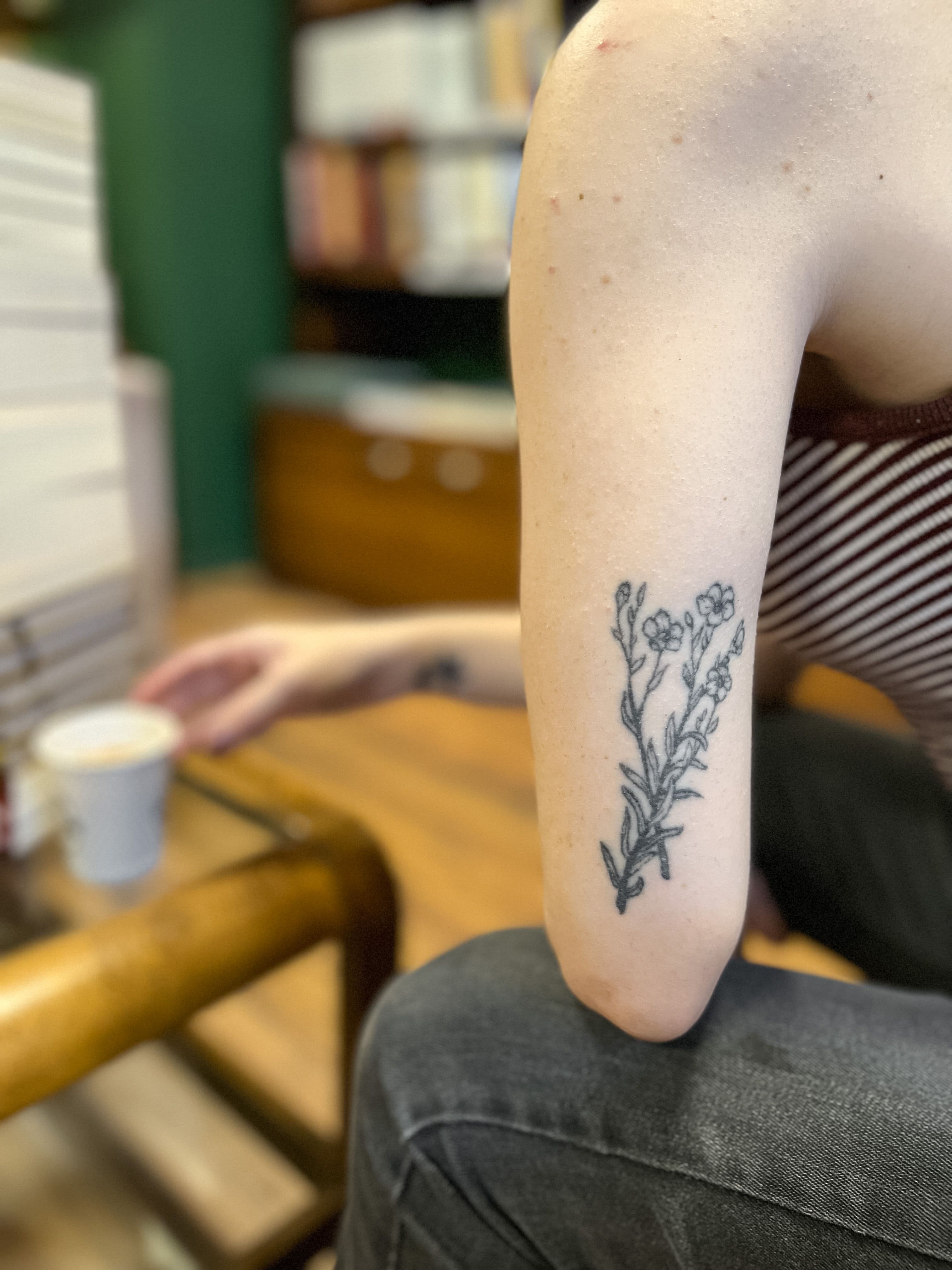 Healed wildflower branch tattoo on an arm